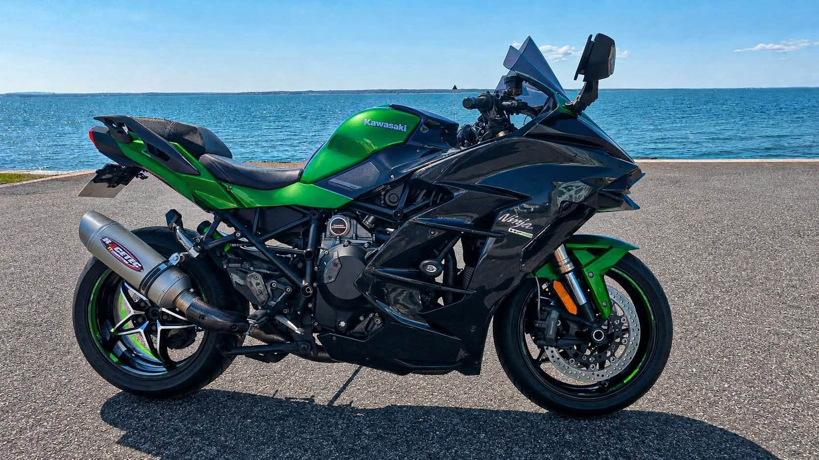 Green and black Kawasaki H2 SX SE 2018 parked by the water